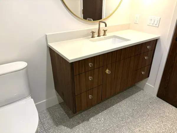 Floating wood bathroom vanity with a stone top
